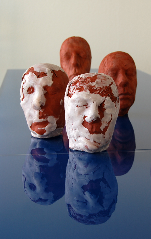 Elf Köpfe, 2009, terracotta, wax, combustible materials, height of one head: 31 cm